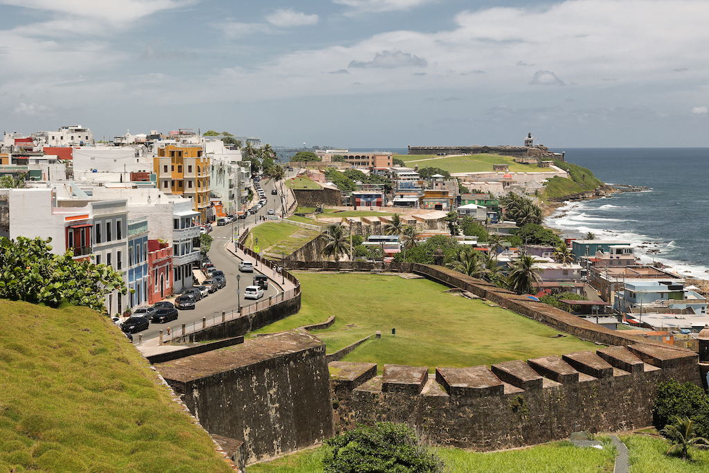 Panoramic view of Old San Juan and the Puerto Rico coastline, showing historic architecture, green spaces and the Atlantic Ocean