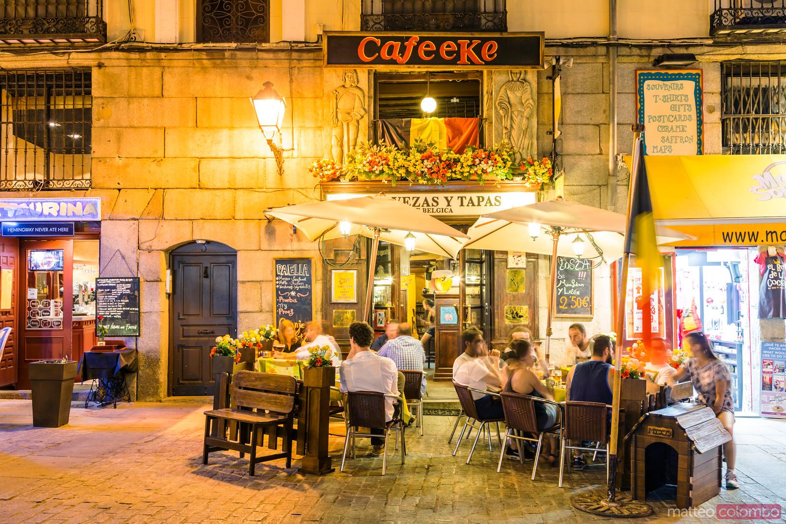 People sharing tapas on an outdoor terrace in Spain in the evening