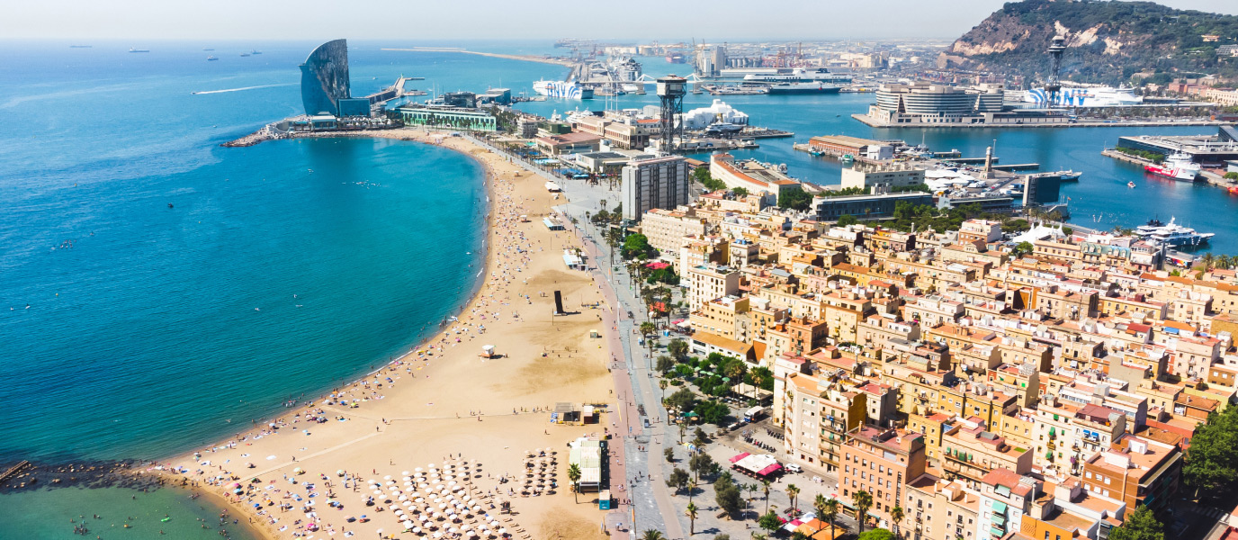 Things to Do in Spain – Beaches, culture, city attractions and outdoor experiences Aerial view of Barcelona’s Barceloneta Beach, Port Vell marina and historic neighborhoods on a sunny day
