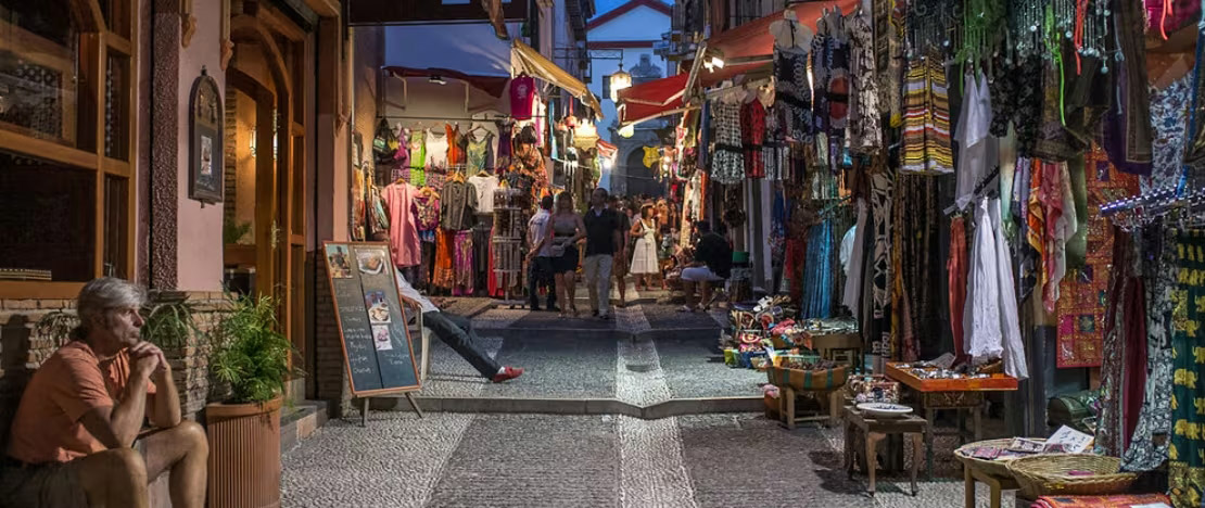 Traditional Spanish market with hanging jamón ibérico and artisan products in a historic setting