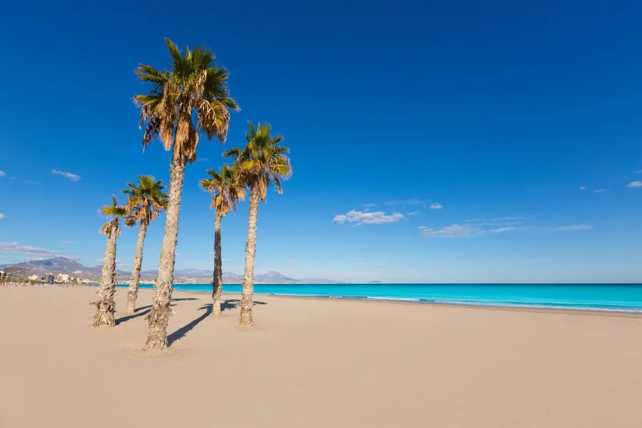 Sunny Mediterranean beach in Spain with clear blue skies, soft sand and warm coastal weather