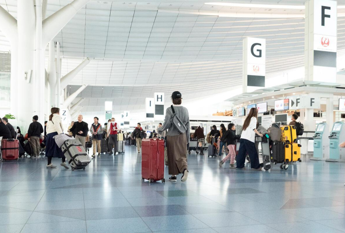 Travelers walking through a busy international airport terminal during the holiday travel season.