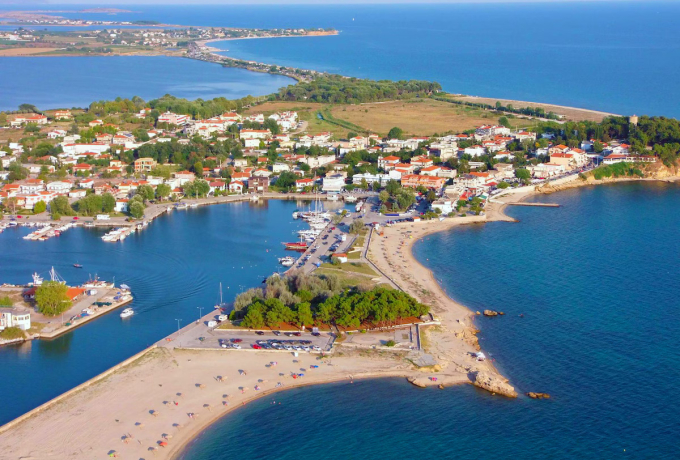 Aerial view of Fanari village port and sandy coastline in Northern Greece