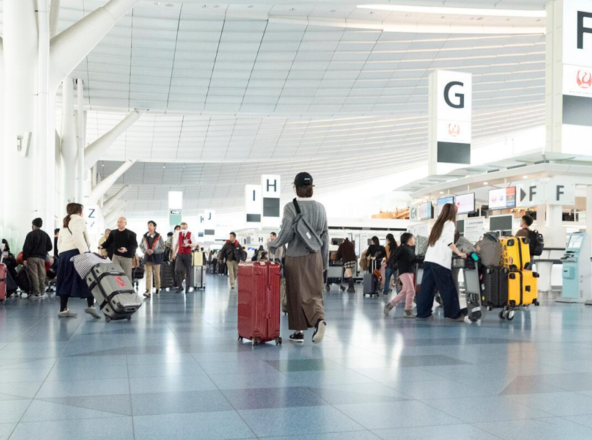 Travelers walking through a busy international airport terminal during the holiday travel season.